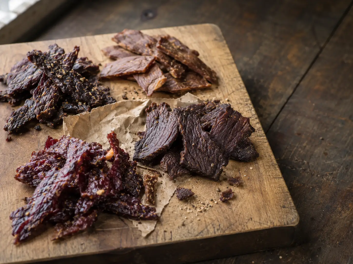 Sliced spicy beef jerky on a wooden board